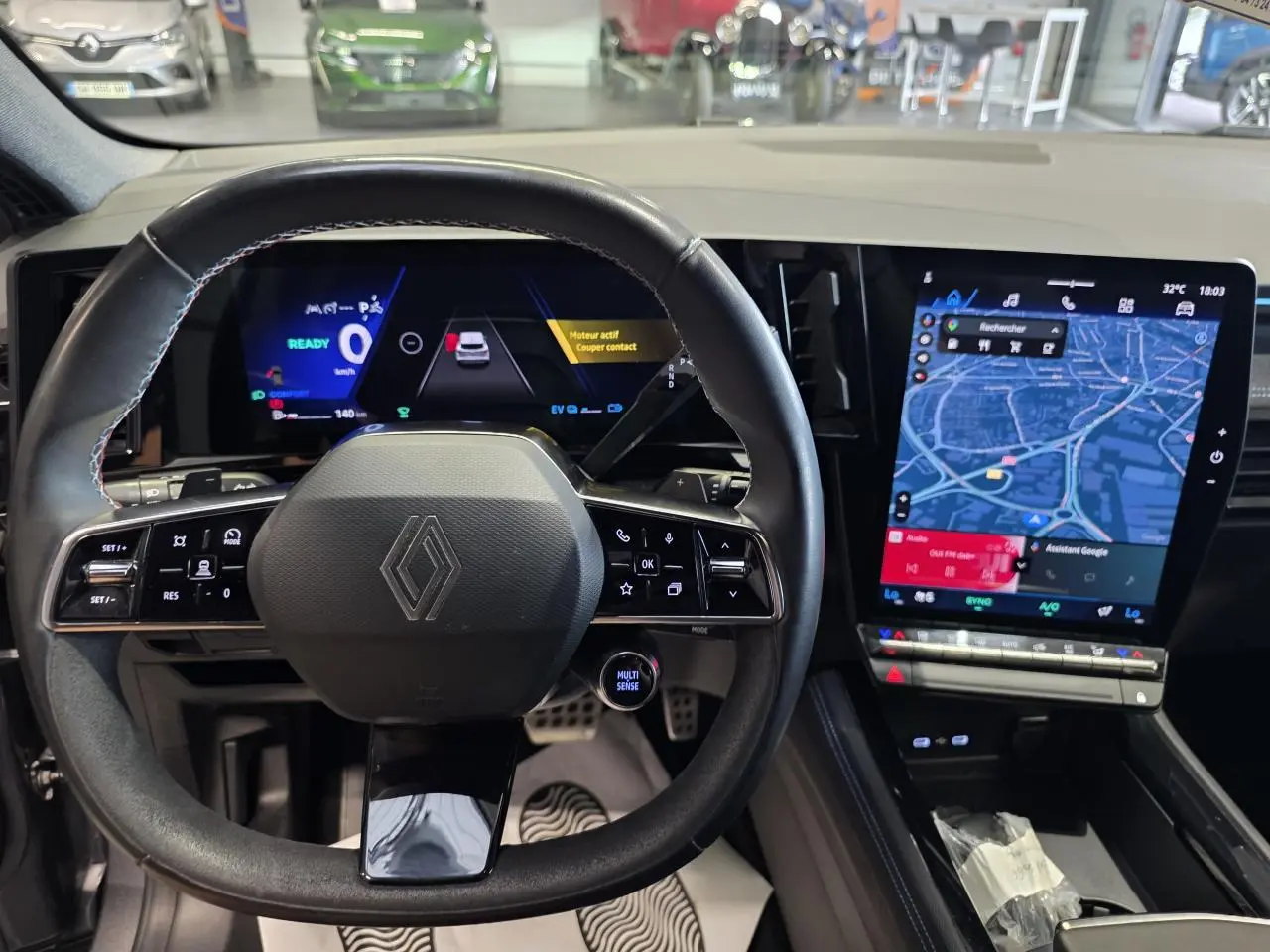 Vue intérieure centrée sur le volant et tableau de bord numérique du Renault Austral gris foncé avec écran tactile vertical.