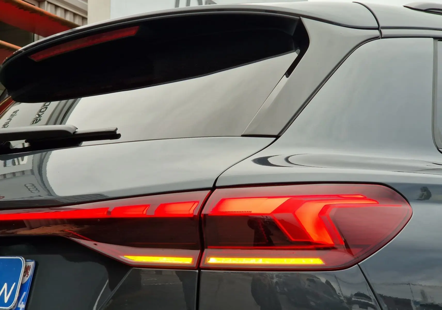 Feu arrière droit allumé sur l'Audi Q6 e-tron Performance S-Line gris Manhattan, vue rapprochée arrière côté droit.