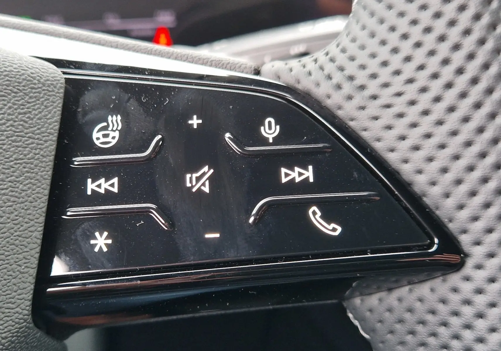 Gros plan sur les commandes du volant de l'Audi Q6 e-tron Performance S-Line gris Manhattan, boutons tactiles noirs.