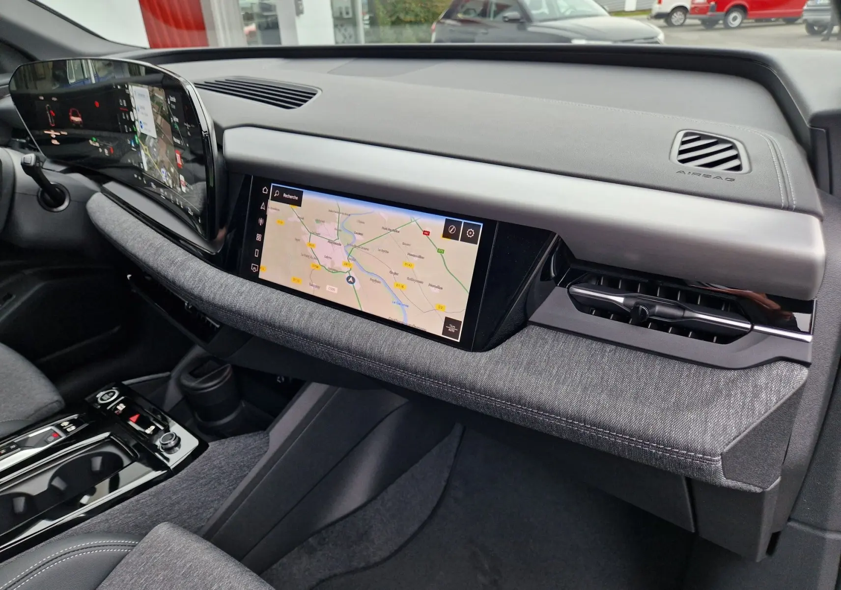 Intérieur de l'Audi Q6 e-tron Performance S-Line 2025, tableau de bord moderne avec écran tactile et finition tissu gris.