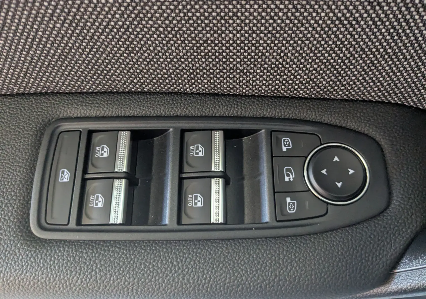 Panneau de commandes des vitres électriques et réglage des rétroviseurs sur la porte côté conducteur d'un Renault Captur gris cassiopée.