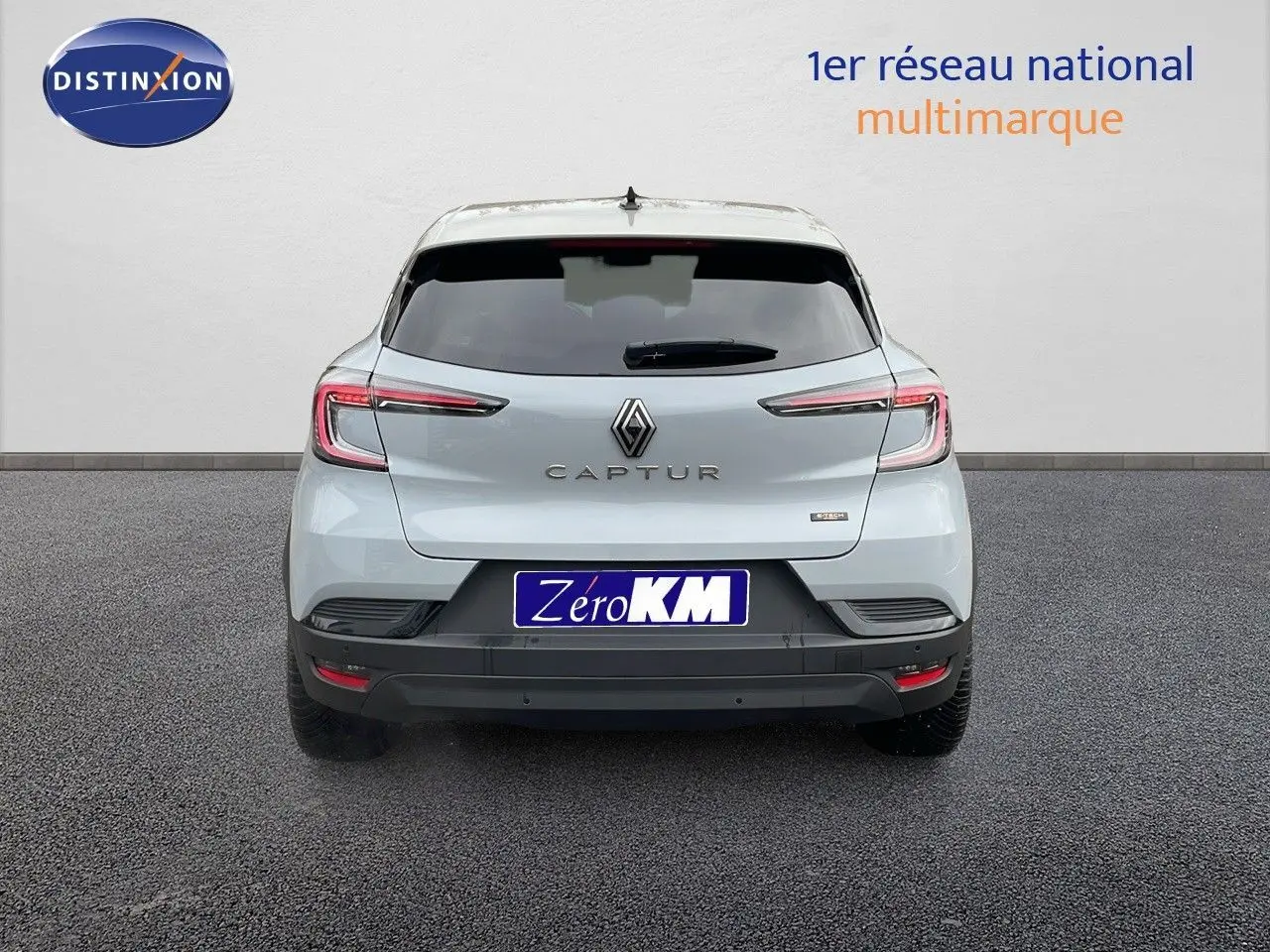 Vue arrière d'un Renault Captur gris Rafale métal avec toit beige, mettant en valeur ses feux LED fins et sa silhouette compacte.