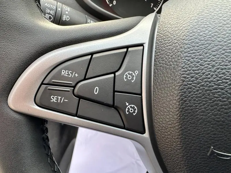 Gros plan sur les commandes de régulateur de vitesse au volant noir du Dacia Sandero Stepway Gris Schiste métallisé 2025