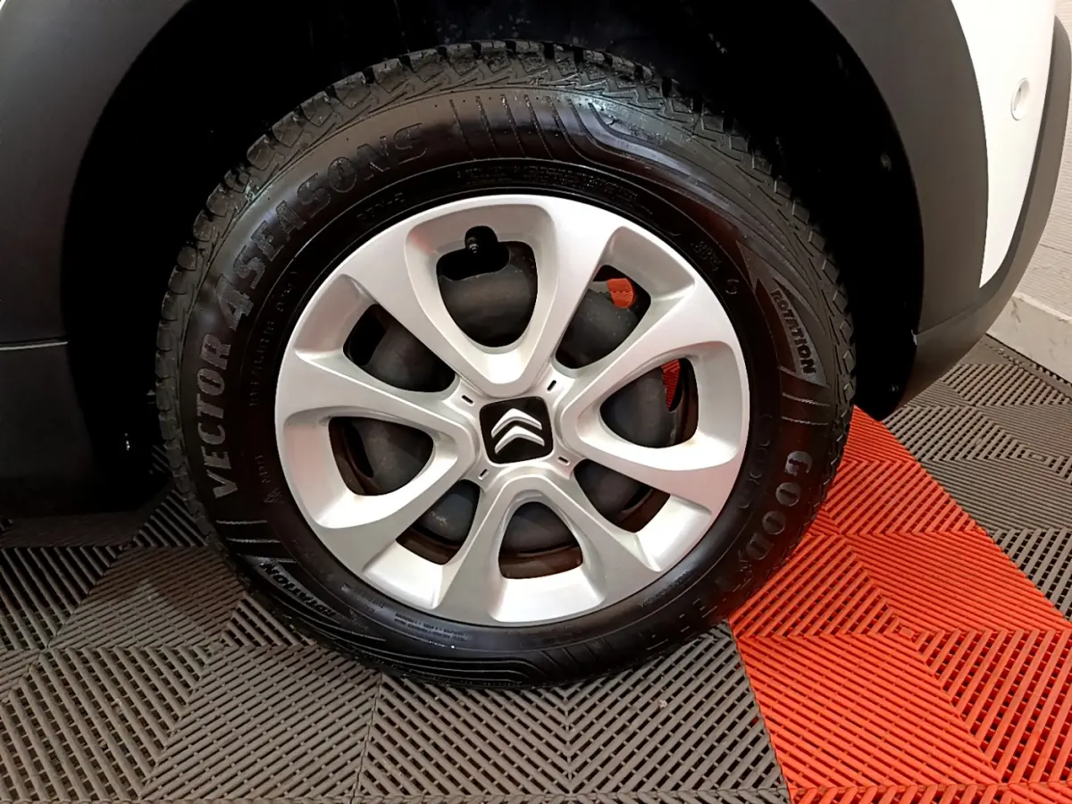 Gros plan sur la roue avant droite d'une Citroën C3 blanche, mettant en valeur la jante alliage et le pneu Goodyear.
