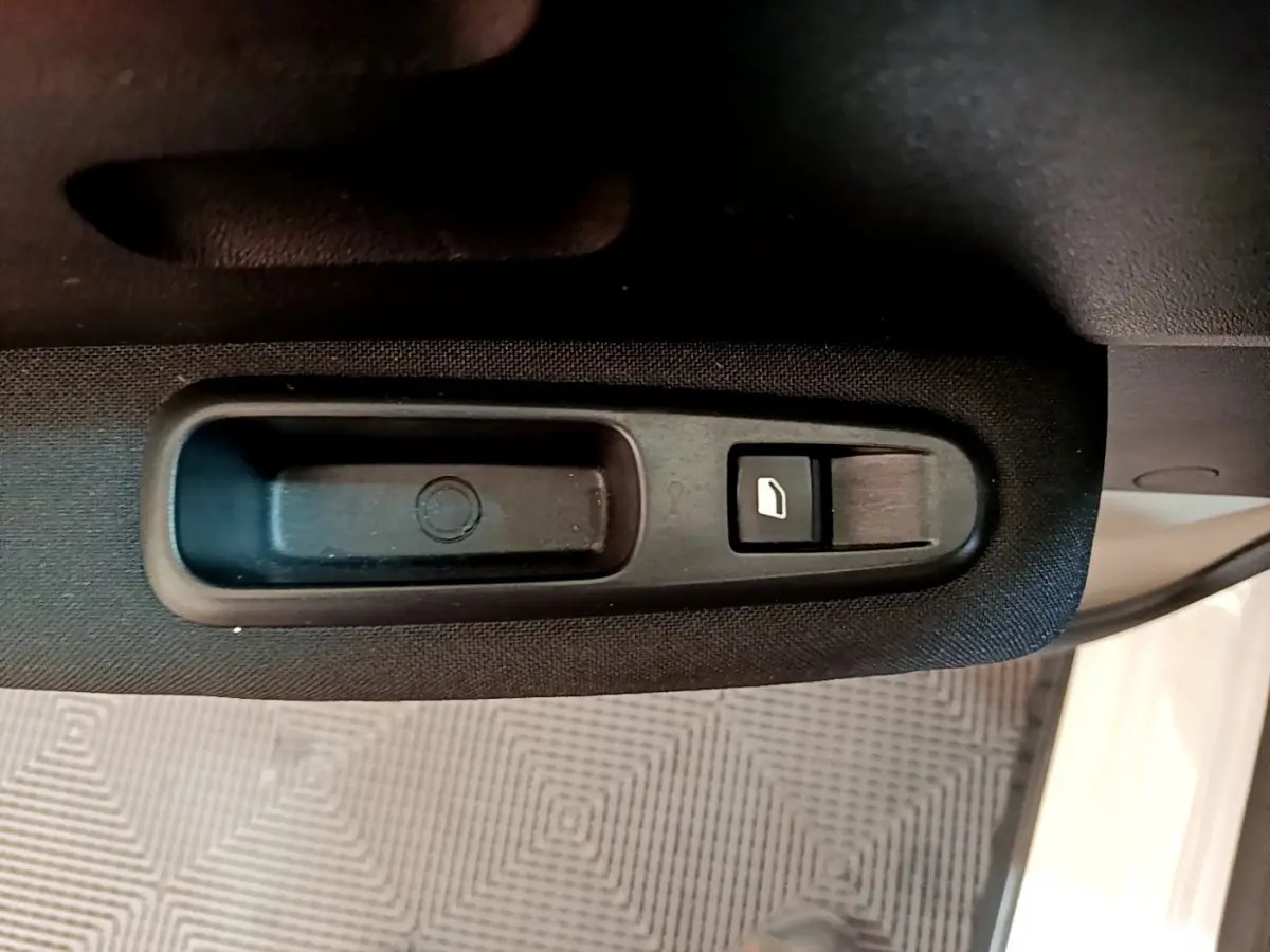 Bouton de commande de lève-vitre côté gauche sur porte intérieure noire d'une Citroën C3 blanche 2019.