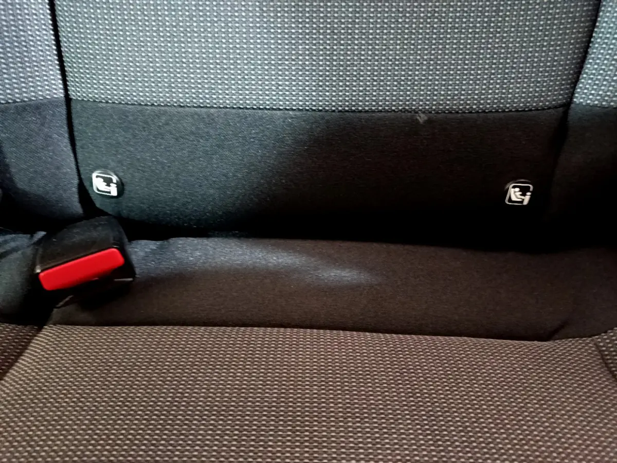Gros plan sur la banquette arrière noire de la Citroën C3 avec fixation Isofix et boucle de ceinture rouge visible.