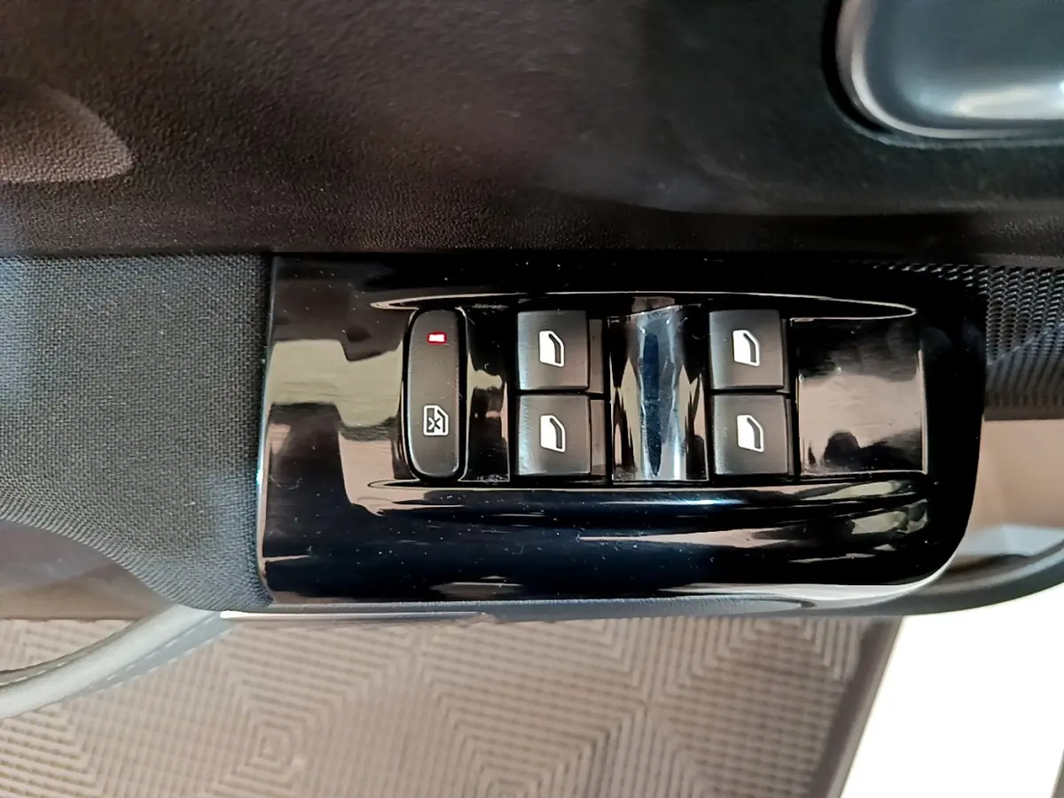 Gros plan sur les commandes de lève-vitres électriques côté conducteur d'une Citroën C3 blanche de 2019.