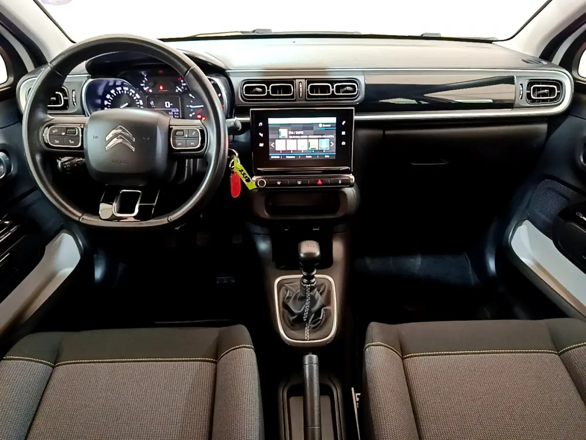 Intérieur de la Citroën C3 PureTech 110 2019 vu de face, tableau de bord noir avec écran tactile central et volant cuir.