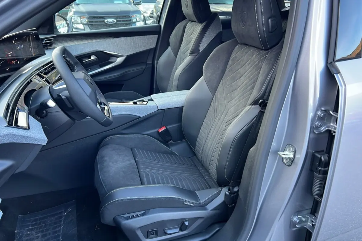 Vue intérieure côté conducteur du Peugeot 3008 Hybrid 145 GT Alcantara 2025, sièges en cuir Alcantara gris et volant cuir multifonctions.