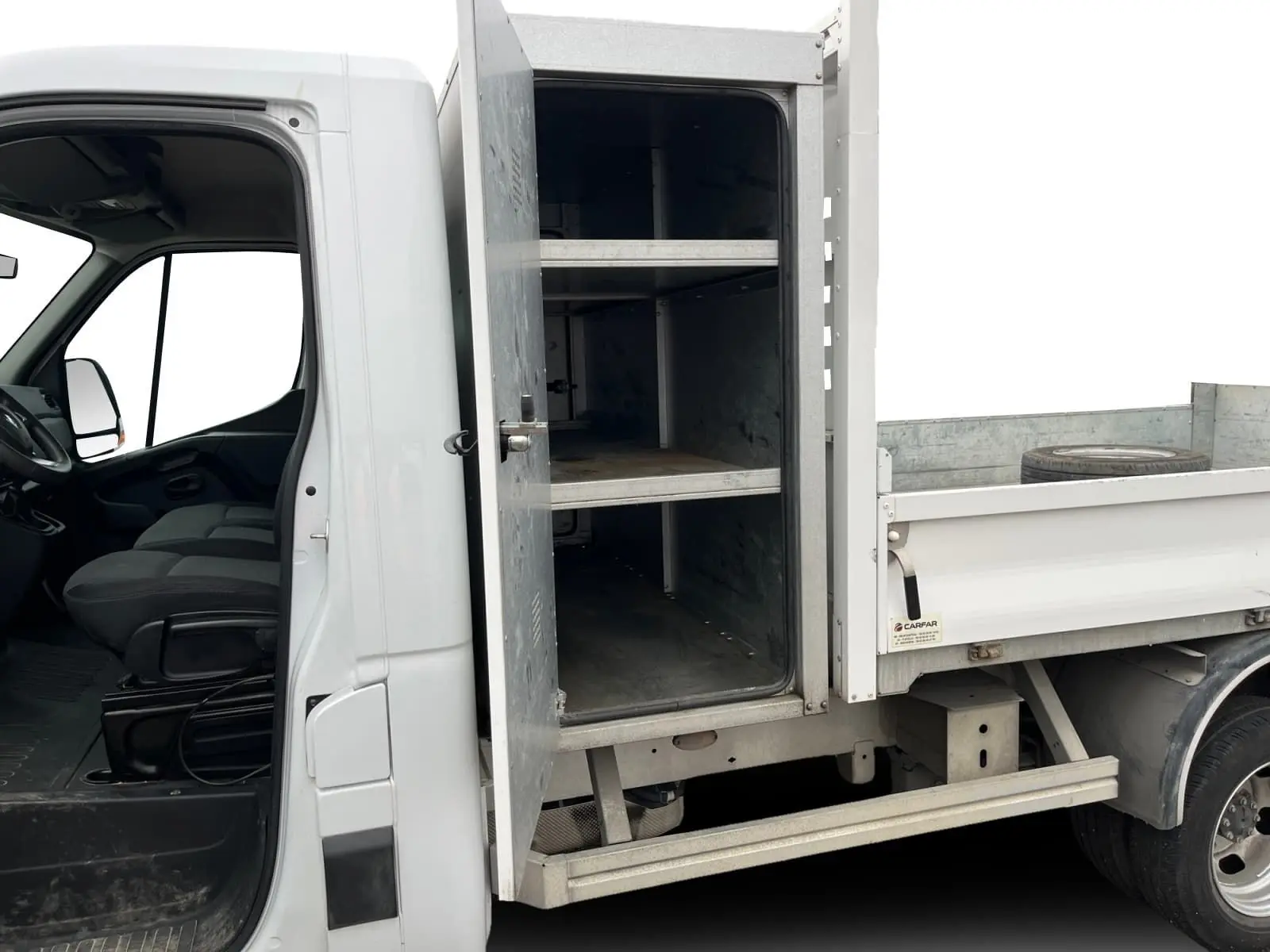 Vue latérale gauche d'un Renault Master blanc 2023 avec cabine ouverte et coffre métallique de rangement visible sur la benne.