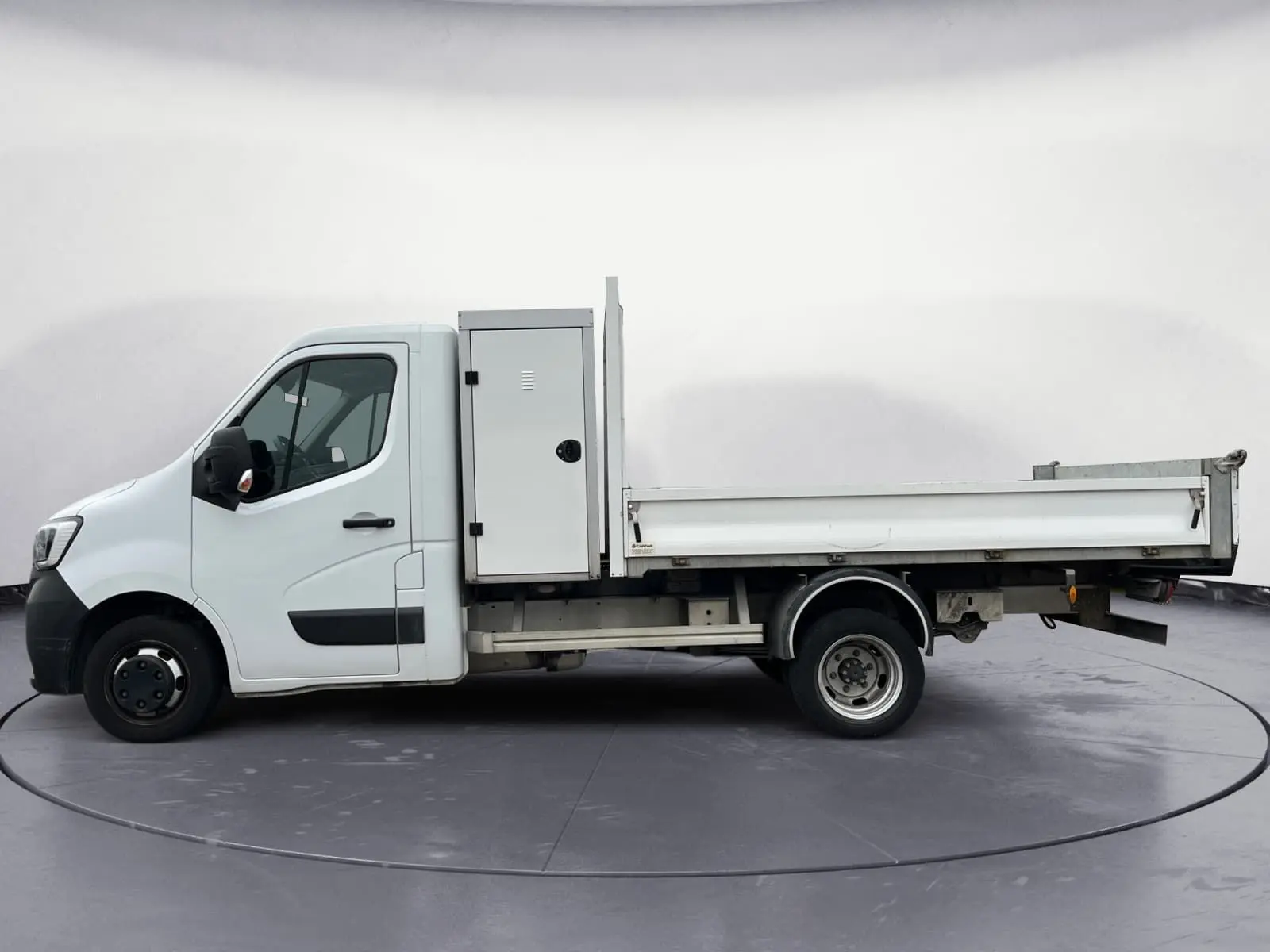 Vue latérale droite d’un Renault Master blanc avec benne, coffre latéral et roues jumelées arrière.