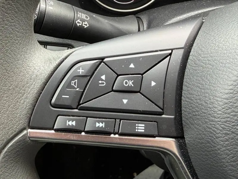 Gros plan sur les commandes noires multifonctions au volant du Nissan Juke 2025, finition Acenta.