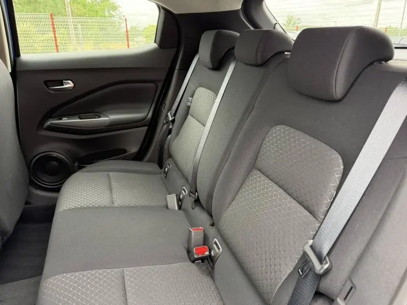 Vue intérieure côté droit des sièges arrière en tissu noir du Nissan Juke 2025, avec ceintures de sécurité et appuie-têtes.