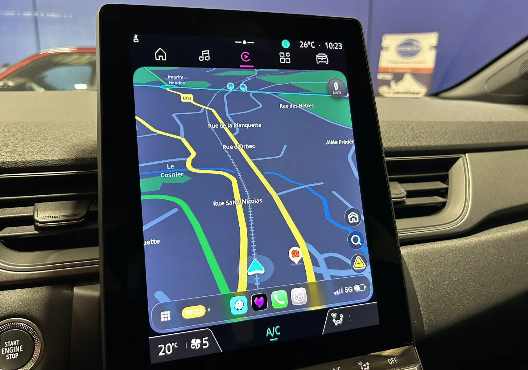 Vue intérieure du tableau de bord du Renault Captur gris Rafale, mettant en valeur l'écran tactile central avec navigation active.