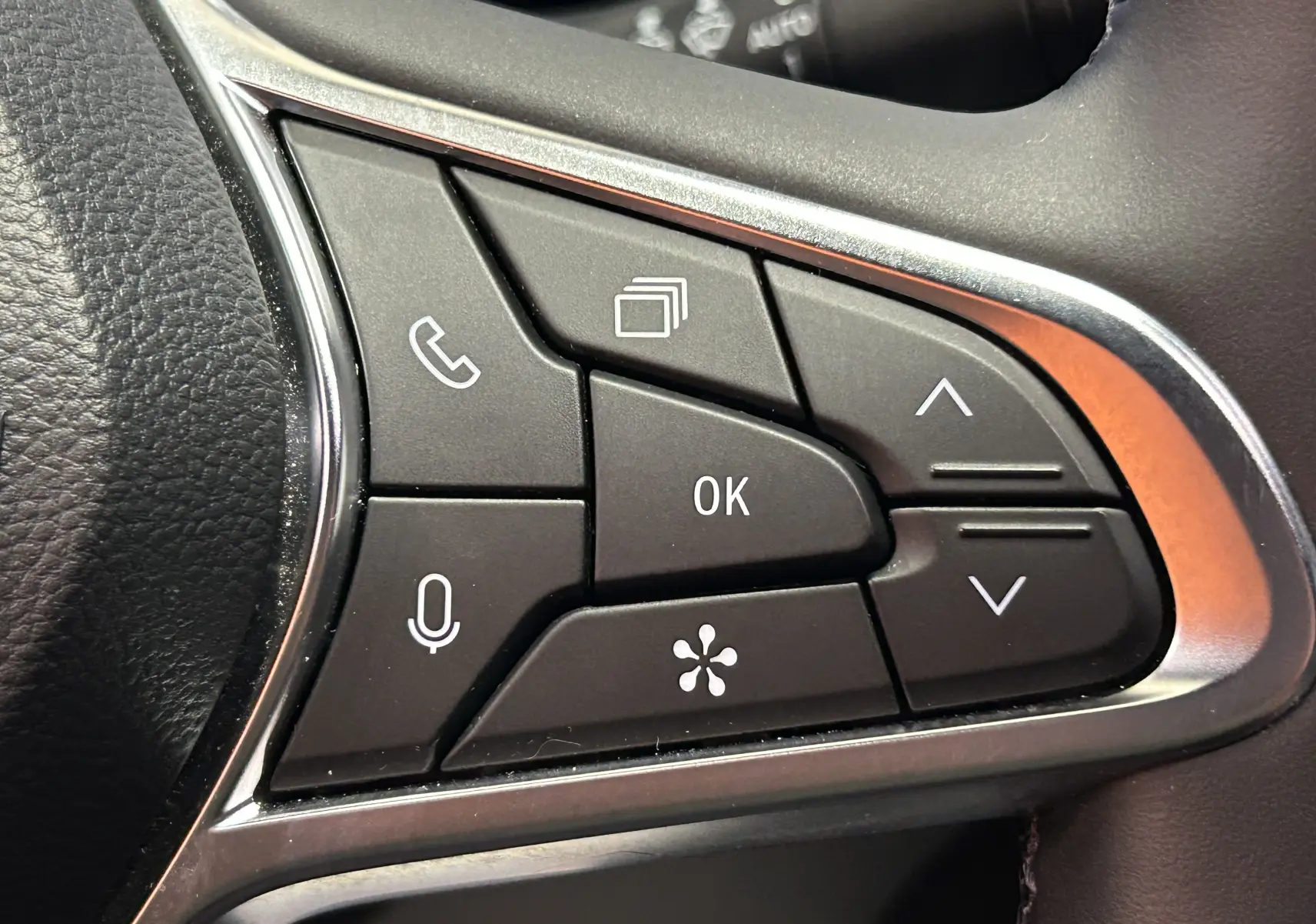 Gros plan sur les commandes multifonctions au volant du Renault Captur gris Rafale, boutons de navigation et appel visibles.