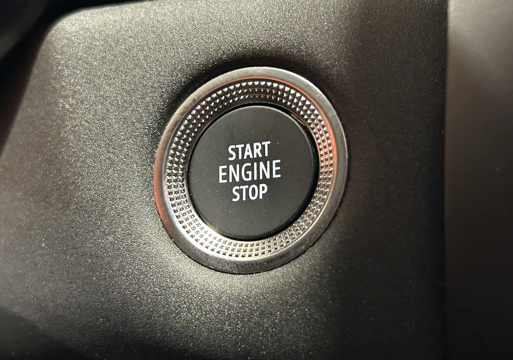 Bouton Start Engine Stop en gros plan sur le tableau de bord noir du Renault Captur gris Rafale 2025.