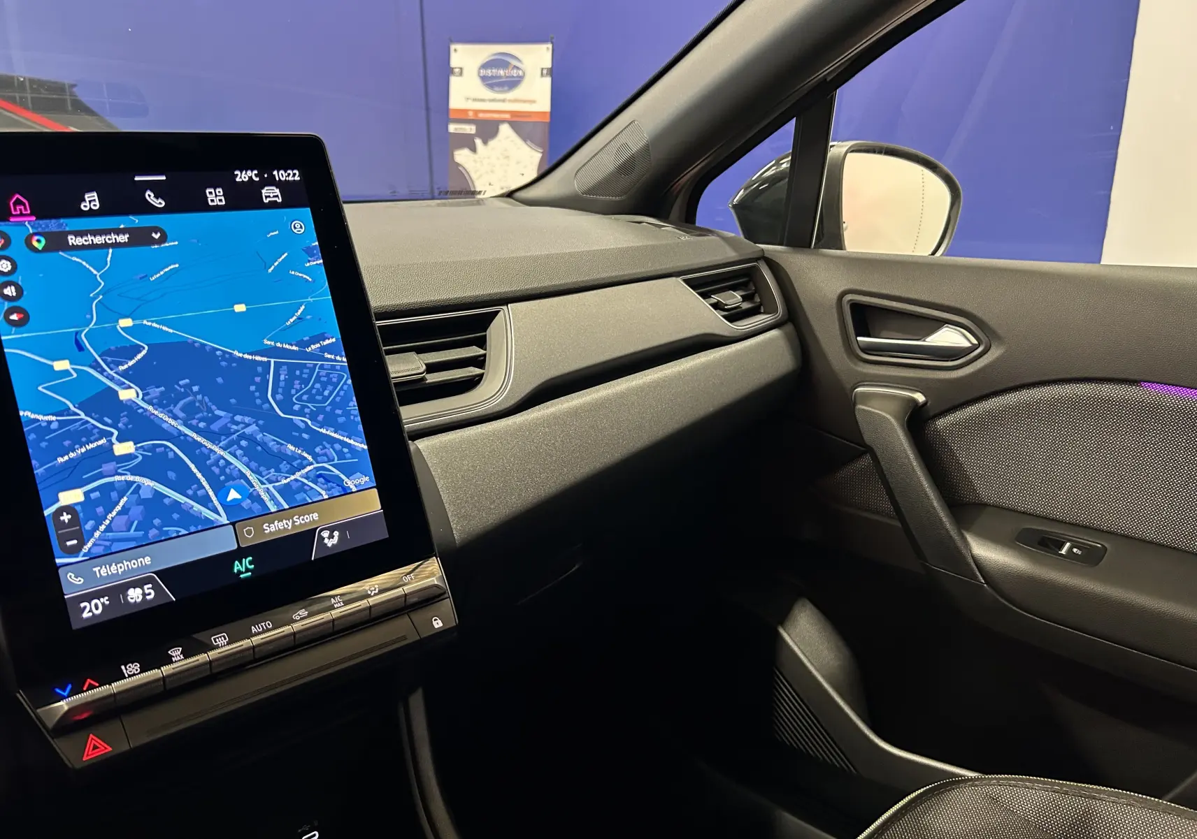 Vue intérieure côté passager du Renault Captur gris Rafale 2025, avec écran tactile affichant la navigation.