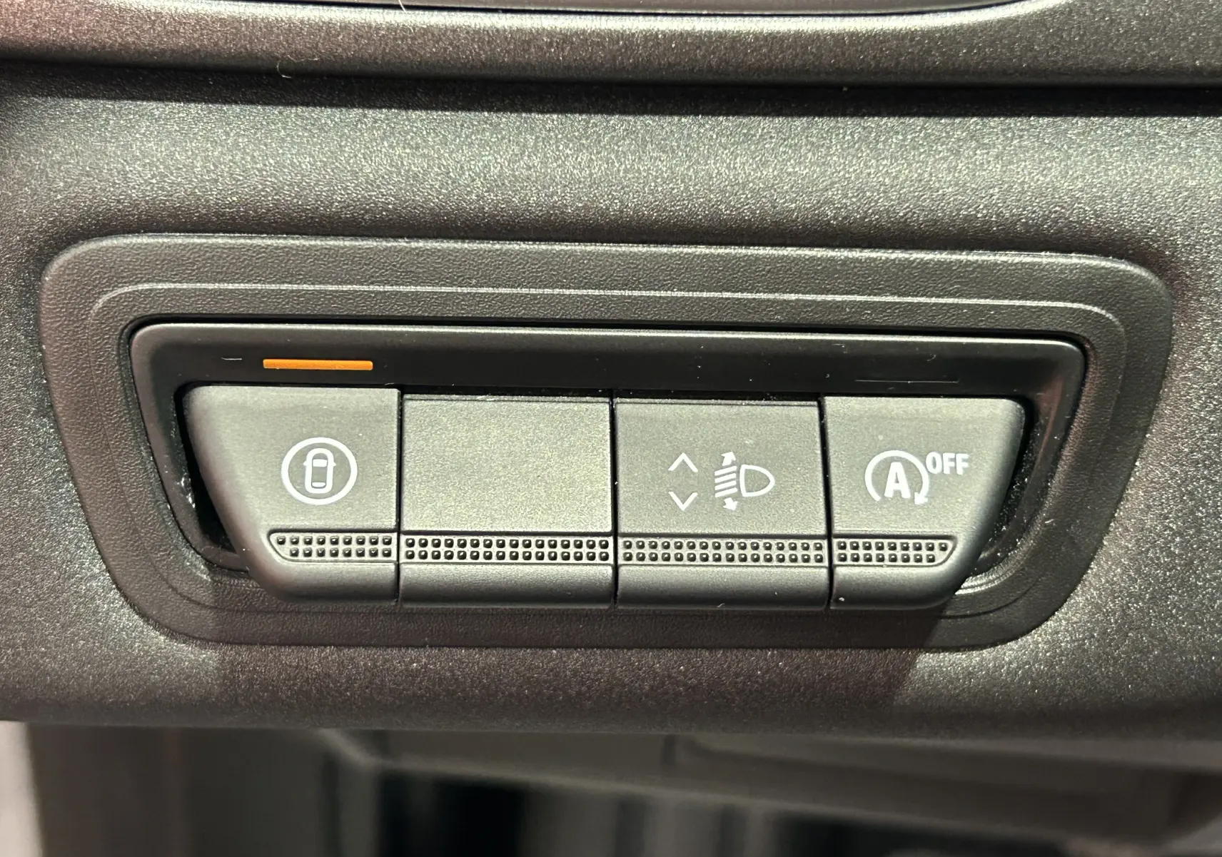 Gros plan sur les boutons de commande du tableau de bord du Renault Captur gris Rafale, avec réglage phares et arrêt auto-start.