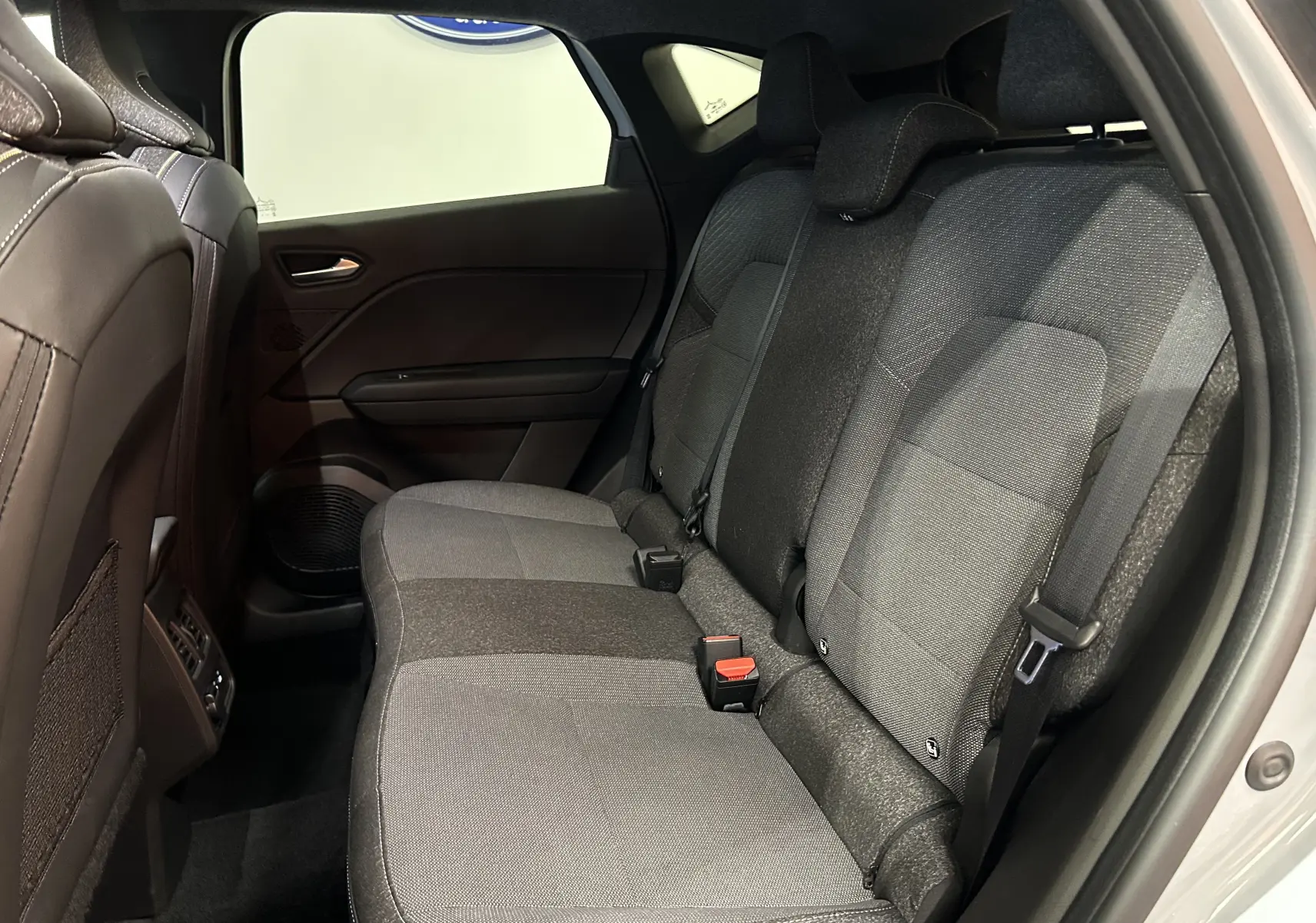 Vue intérieure côté droit des sièges arrière gris tissu du Renault Captur II Ph.2, montrant les appuie-têtes et ceintures de sécurité.