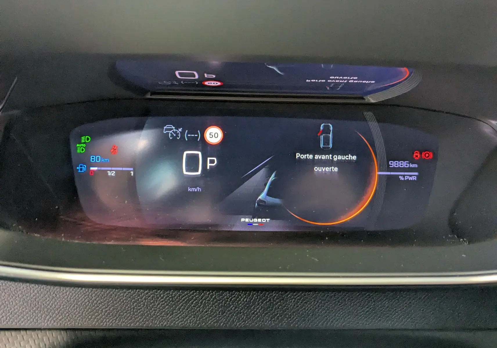 Tableau de bord numérique de la Peugeot 208 Hybrid 145CH GT affichant porte avant gauche ouverte et 9886 km.