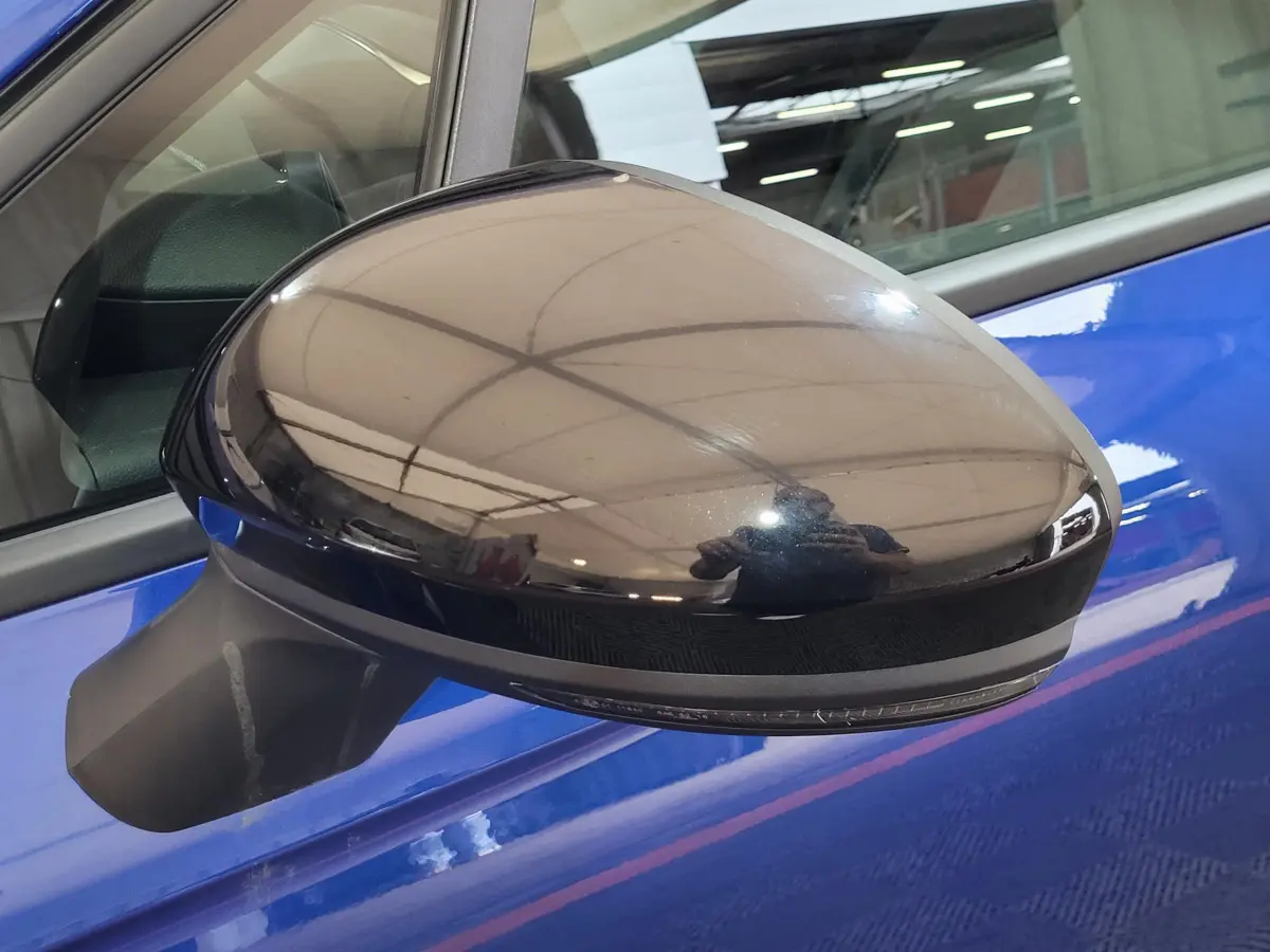 Rétroviseur noir brillant côté gauche sur porte bleu vif d'une Renault Clio Evolution Blue dCi 100 2025.