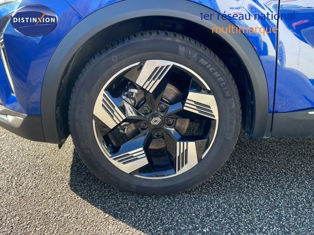 Gros plan sur la roue avant droite du Renault Symbioz bleu iron metal avec jante alliage noire et argentée design moderne.