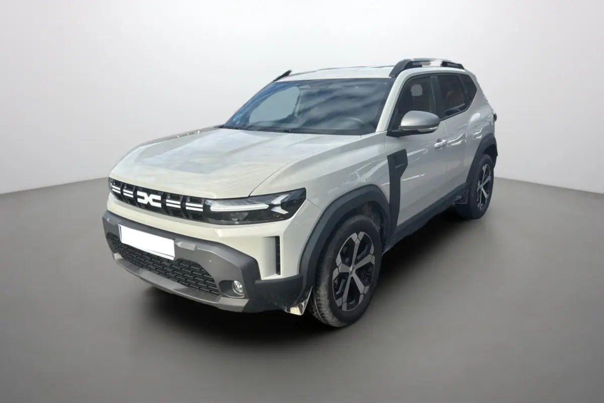 Dacia Duster TCE 130 4x2 Journey sandstone vue 3/4 avant droit avec barres de toit et jantes alu 18 pouces.