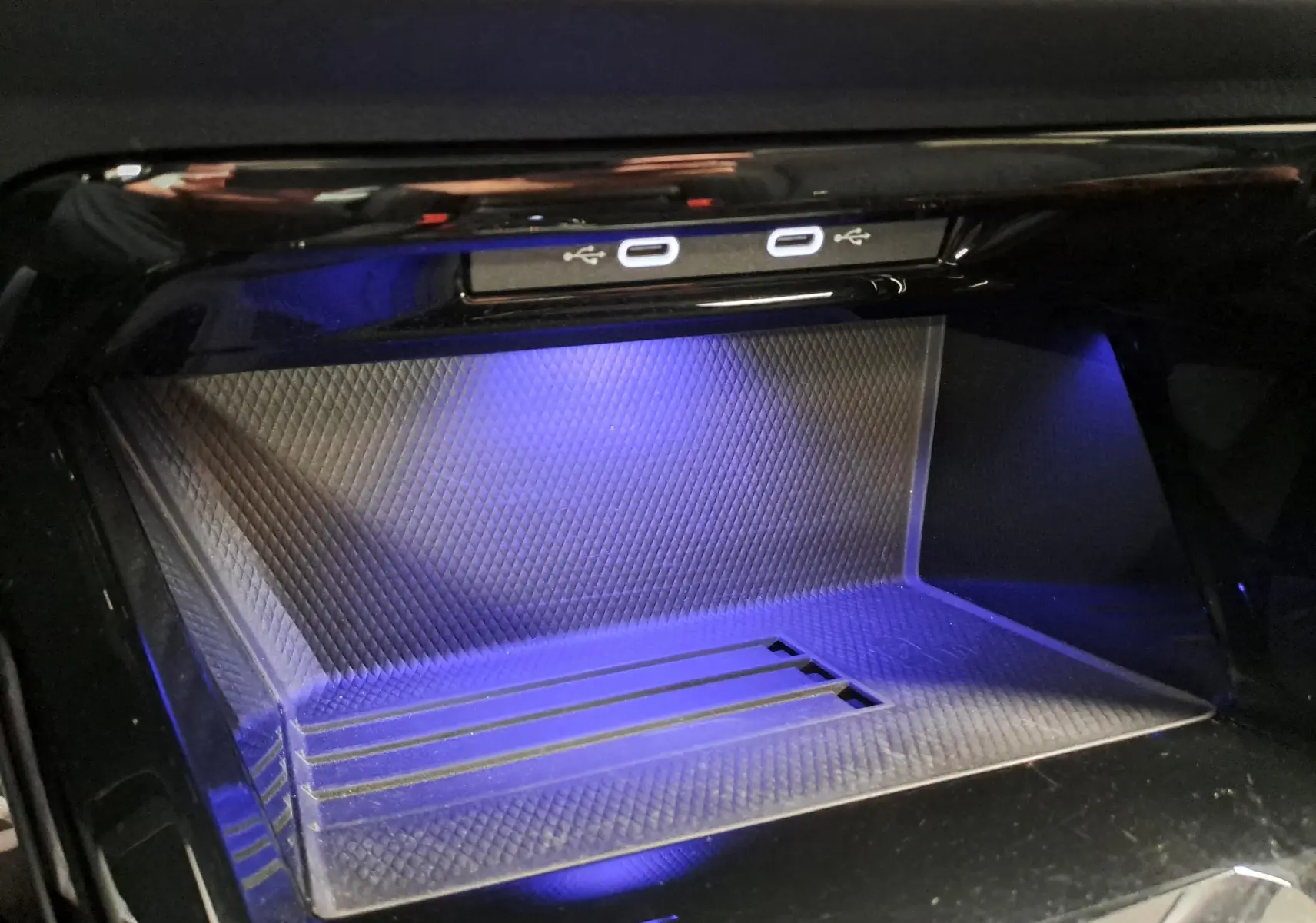 Gros plan sur la console centrale avec ports USB-C éclairés en bleu à l'intérieur d'une Volkswagen Golf Bleu Anémone 2024.
