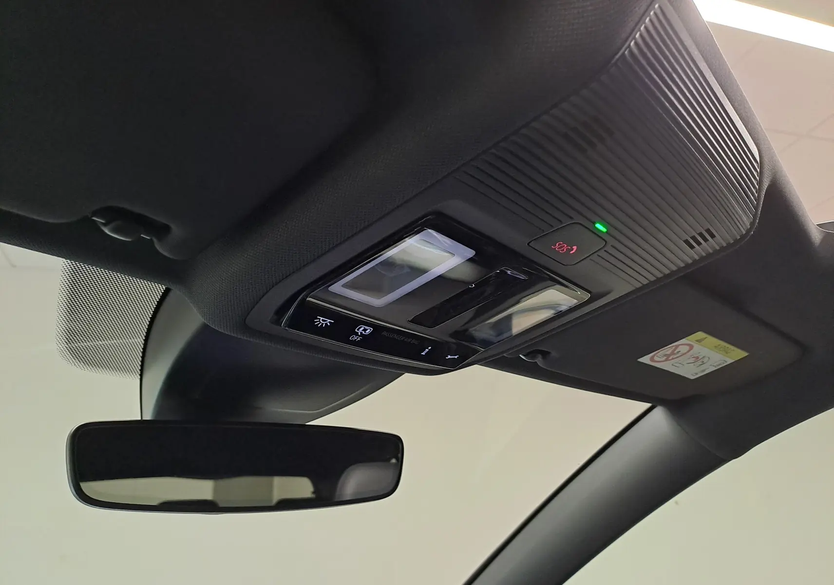 Vue intérieure du toit ouvrant panoramique avec commandes d'éclairage et bouton SOS sur Volkswagen Golf Bleu Anémone 2024.
