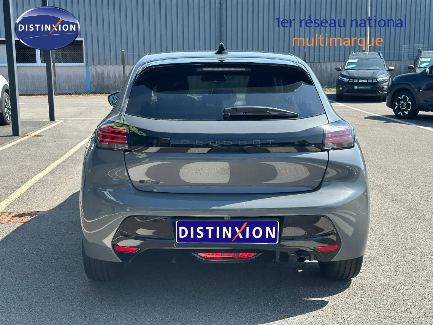 Vue arrière d'une Peugeot 208 gris Selenium 2025 avec feux LED et logo Peugeot en relief sur le hayon.