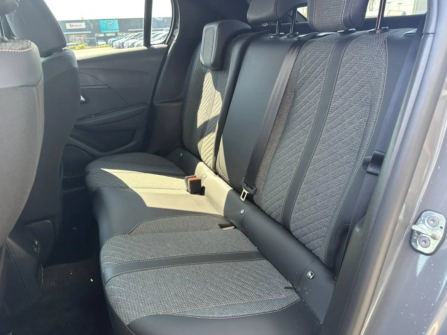 Vue intérieure côté droit sur la banquette arrière tissu gris et cuir noir de la Peugeot 208 2025.