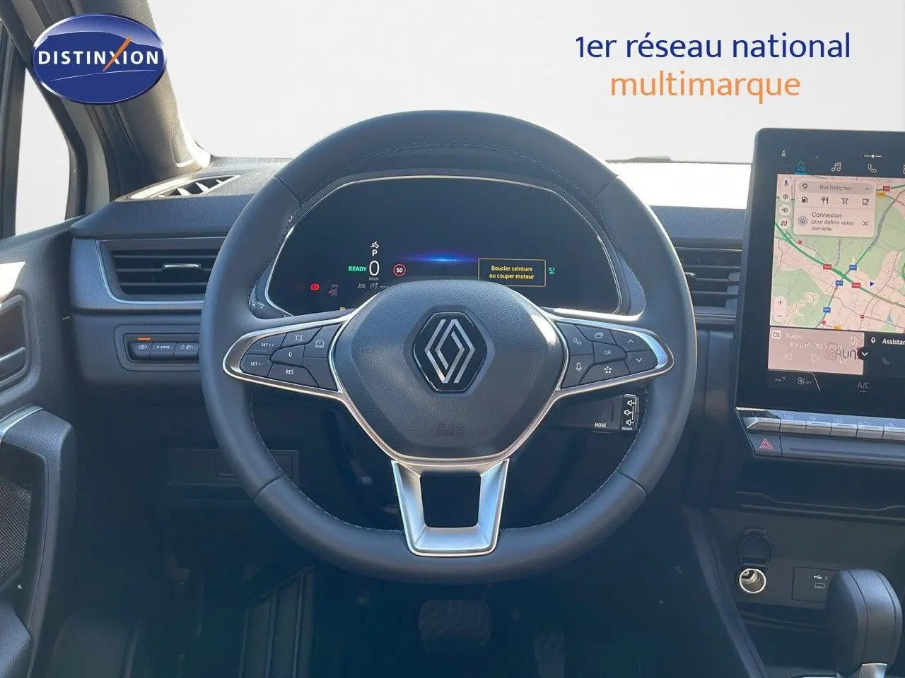 Vue centrée sur le volant du Renault Captur E-Tech hybride 2025 avec tableau de bord numérique et écran tactile GPS.