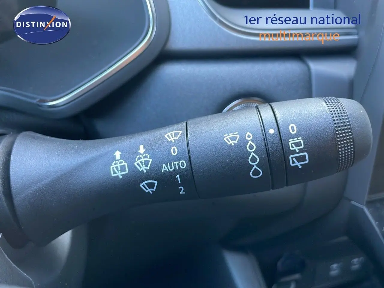 Gros plan sur la commande d'essuie-glace du Renault Captur blanc nacré, version hybride 2025, intérieur gris.