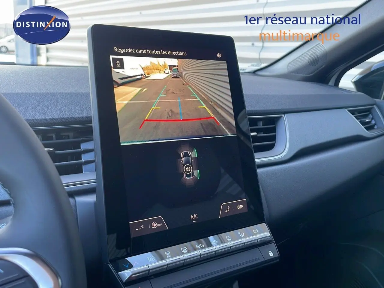 Écran central tactile affichant la caméra de recul dans l'habitacle gris du Renault Captur blanc nacré toit noir.