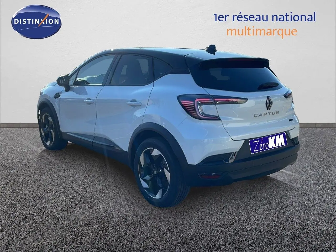 Vue 3/4 arrière droite d'un Renault Captur blanc nacré avec toit noir, mettant en valeur ses feux LED et jantes bi-ton.