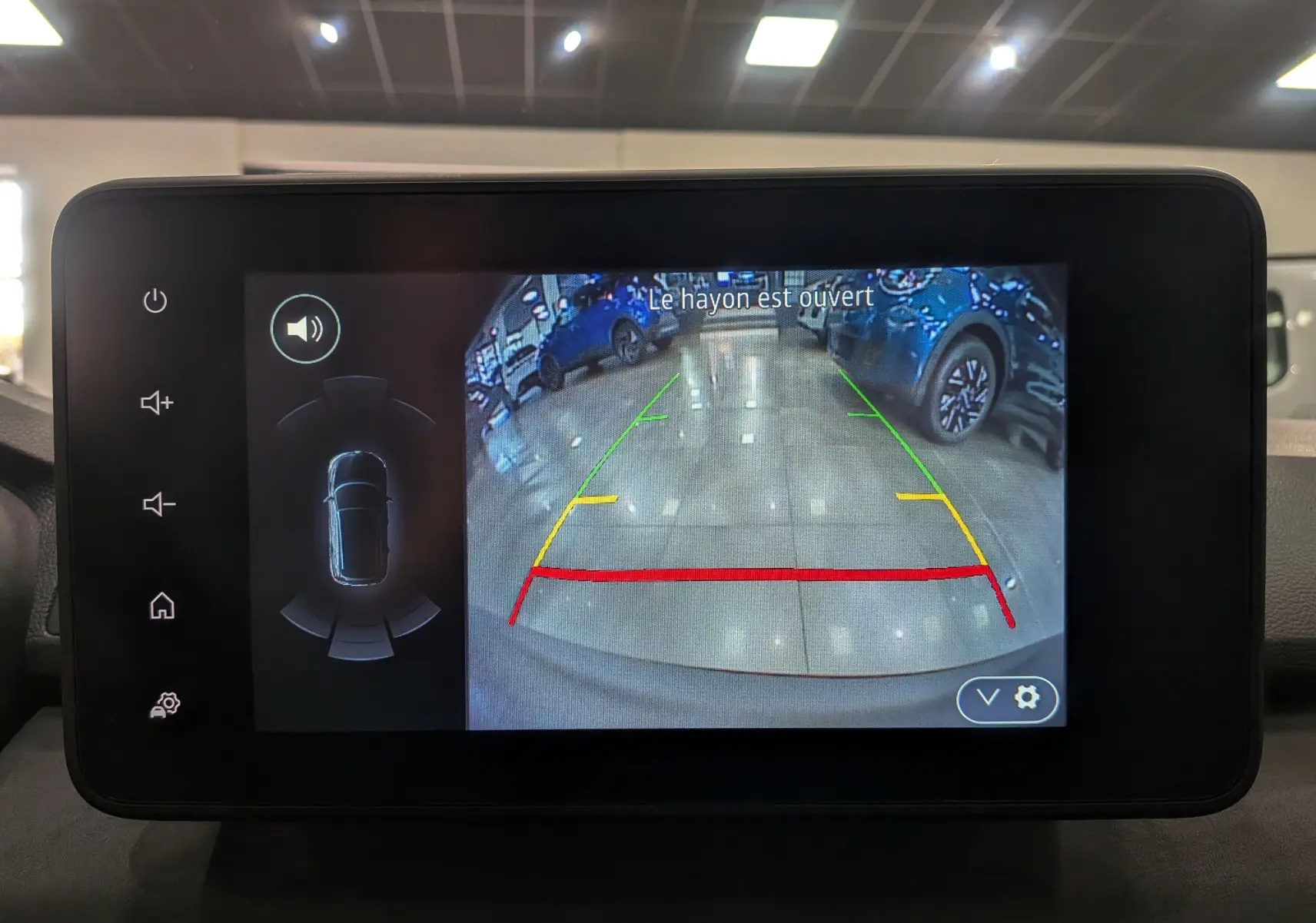 Affichage de la caméra de recul du Dacia Sandero Stepway TCe 110 Gris Schiste, avec lignes de guidage colorées et alerte hayon ouvert.