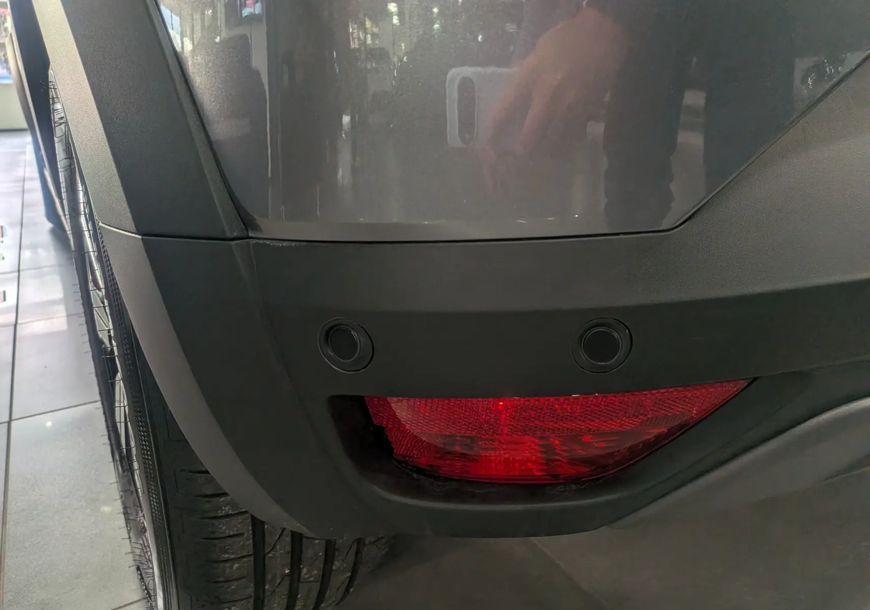 Gros plan sur le feu arrière droit et le pare-chocs gris schiste d'une Dacia Sandero Stepway TCe 110 2025.