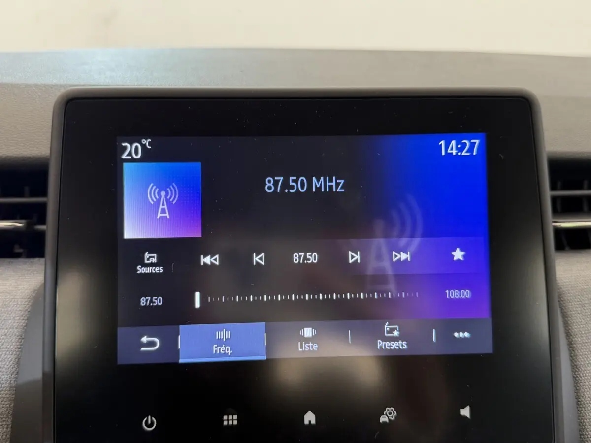 Écran tactile central de la Renault Clio noir affichant la radio FM sur fréquence 87,50 MHz à 14h27