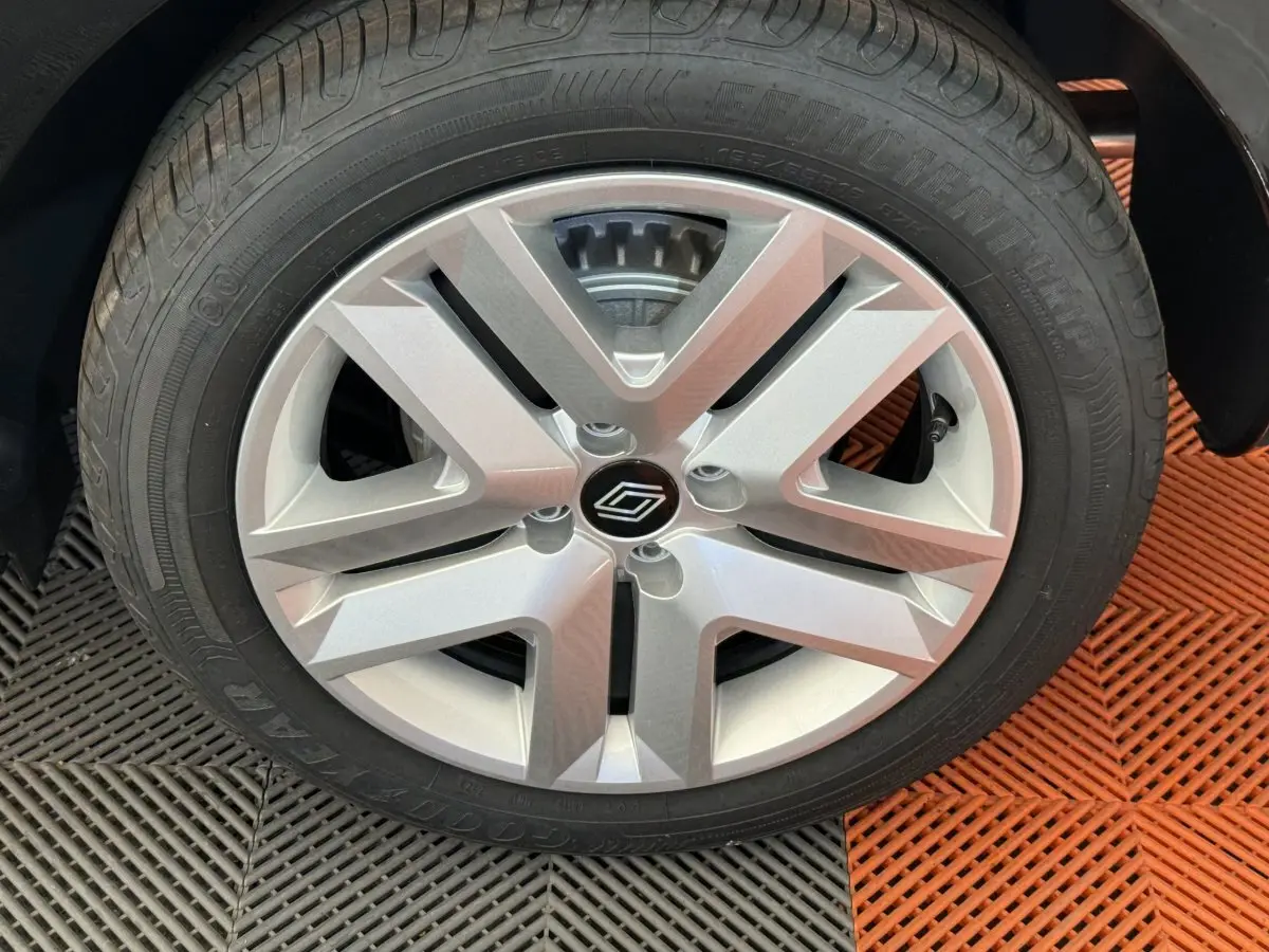 Gros plan sur la jante argentée et le pneu Goodyear d'une Renault Clio noire, vue côté droit.