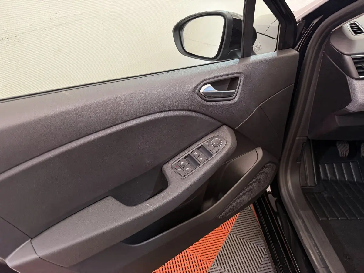Intérieur côté gauche de la porte avant noire de la Renault Clio 2025 avec commandes de vitres et rétroviseur.