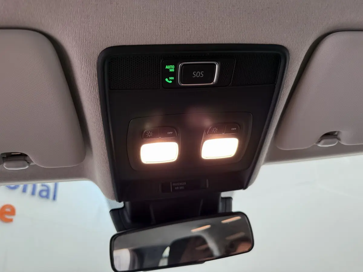 Plafonnier intérieur allumé avec bouton SOS et miroir rétro central d'une Renault Clio noire 2025 vue de dessous.