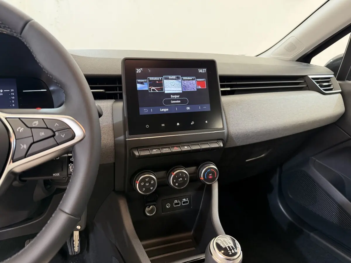 Vue intérieure du tableau de bord et console centrale de la Renault Clio noire 2025 avec écran tactile et boîte manuelle.