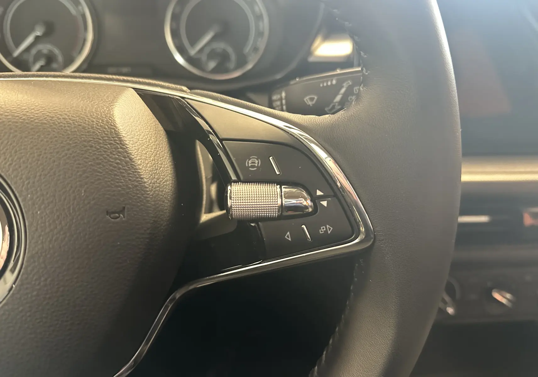 Gros plan sur les commandes à droite du volant cuir noir d'une Skoda Fabia Ambition 2023, avec tableau de bord partiellement visible.