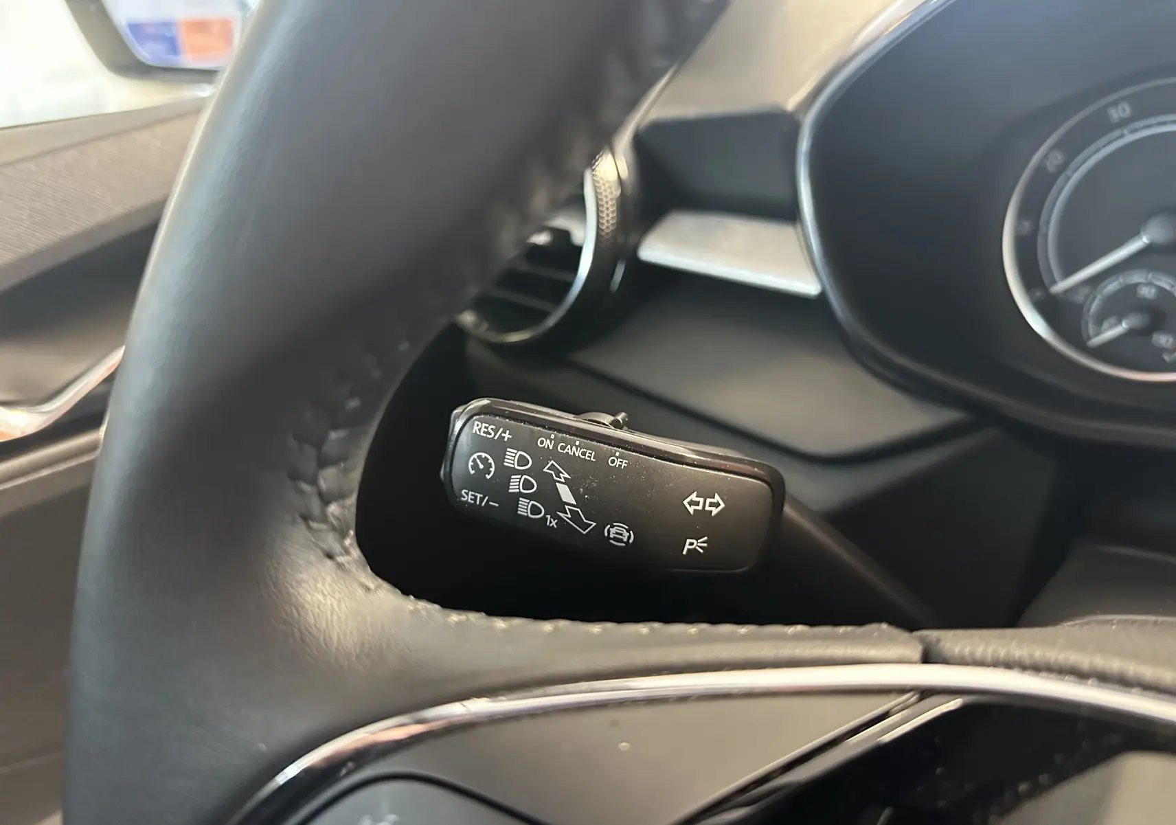 Gros plan sur la commande de régulateur de vitesse derrière le volant d'une Skoda Fabia Ambition gris argent 2023.