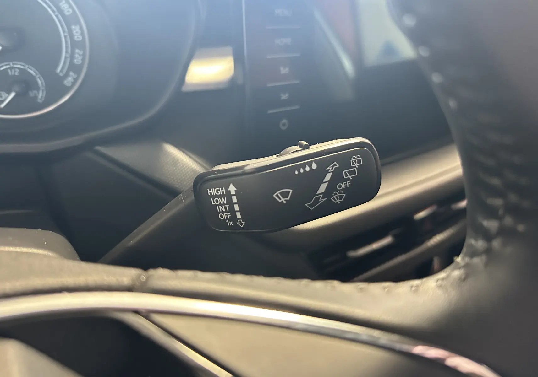 Gros plan sur la manette d’essuie-glace à gauche du volant dans l’habitacle d’une Skoda Fabia gris argent 2023.