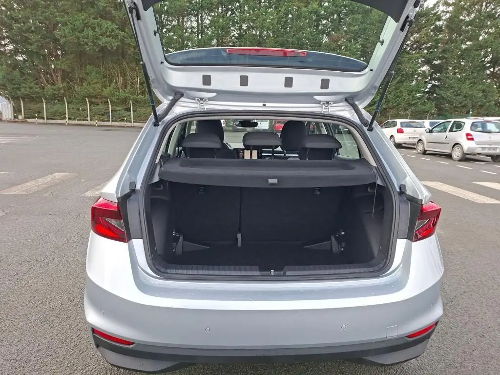 Vue arrière du coffre ouvert d'une Skoda Fabia Ambition gris argent 2023, montrant l'espace de chargement vide.