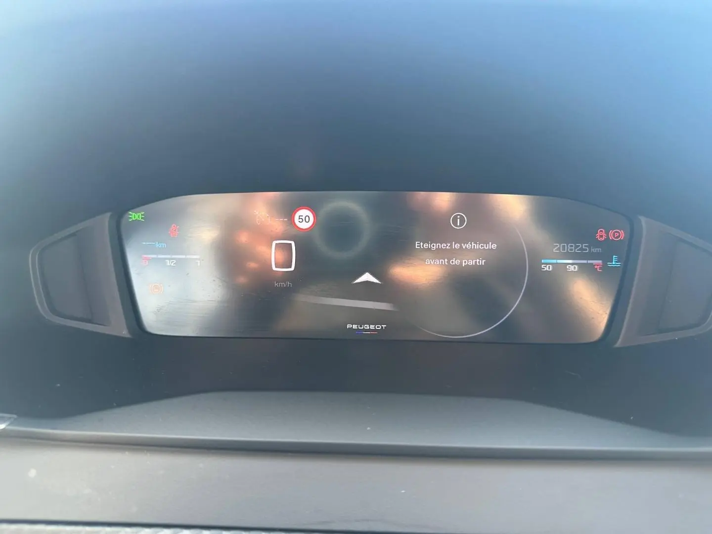 Tableau de bord numérique de Peugeot 208 2025 affichant un message d'arrêt et la vitesse à 0 km/h.