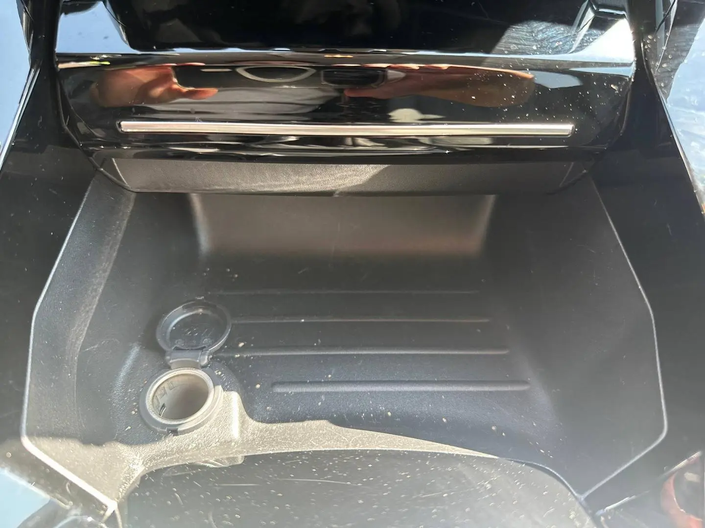 Rangement central ouvert avec prise 12V visible dans l’habitacle de la Peugeot 208 gris Selenium.