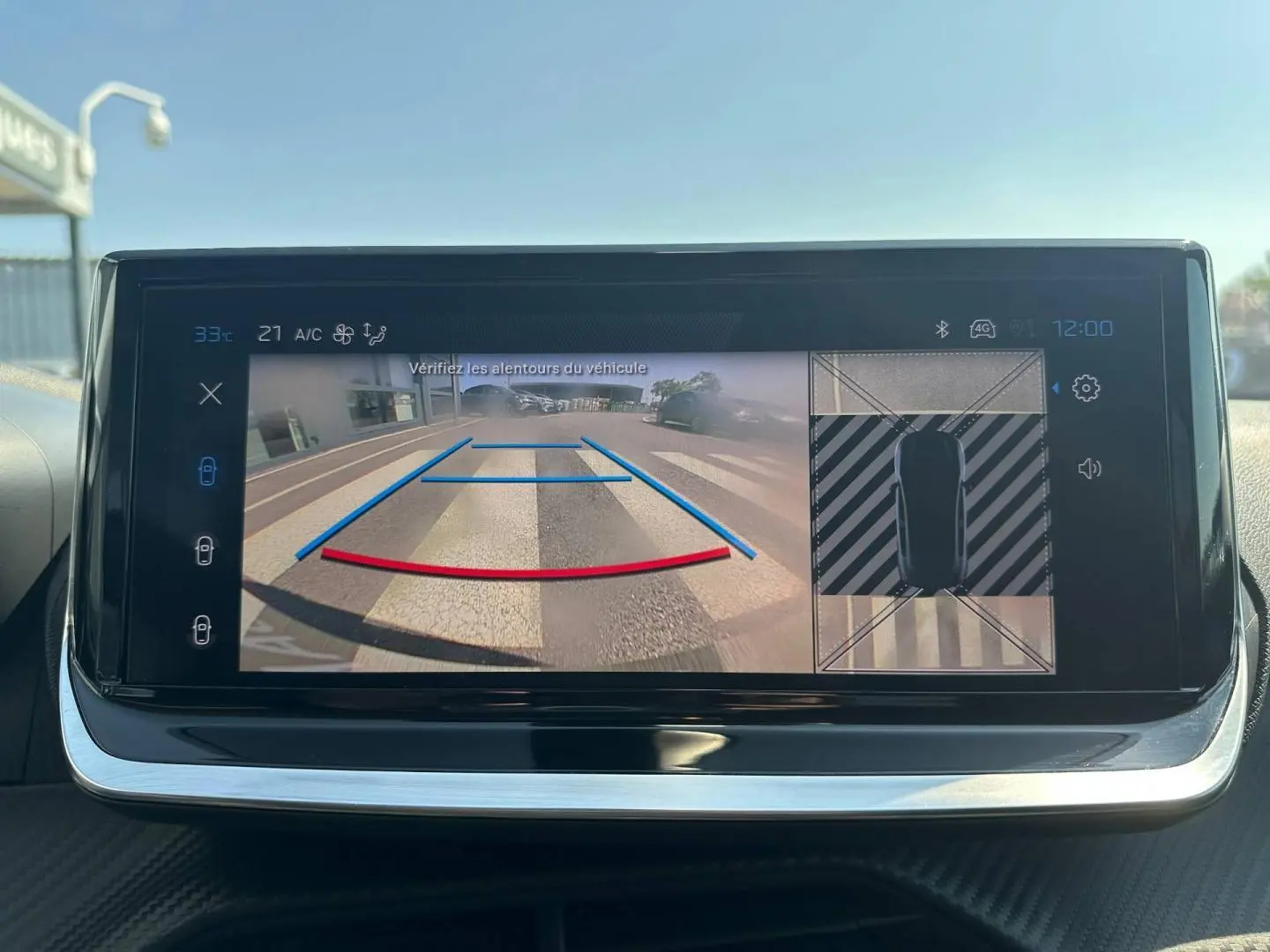 Écran tactile de la Peugeot 208 2025 montrant la caméra de recul et l’aide au stationnement en vue intérieure.