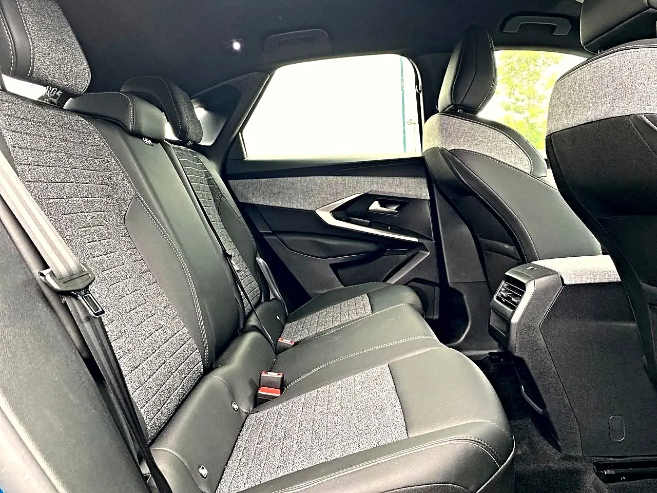 Vue intérieure arrière côté droit du Peugeot 3008 1.2 hybrid 145 allure 2025, sièges bi-matière gris et noir.